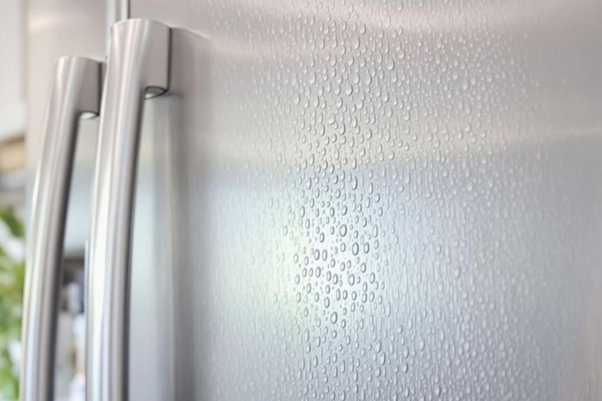 Close-up of a silver refrigerator featuring water droplets, highlighting its sleek and modern design.