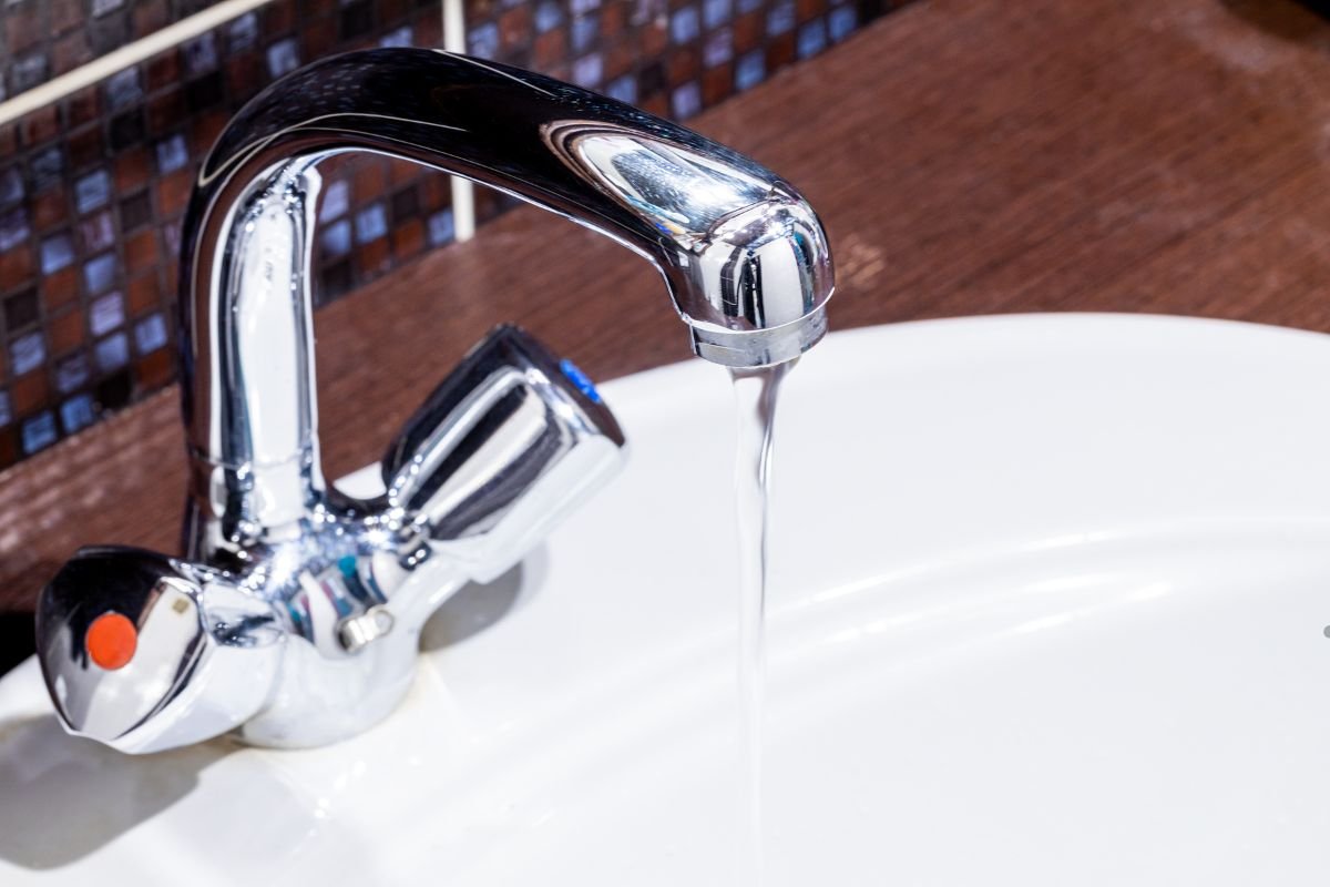  Water flows from a sink faucet, highlighting concerns related to low water pressure in household plumbing.